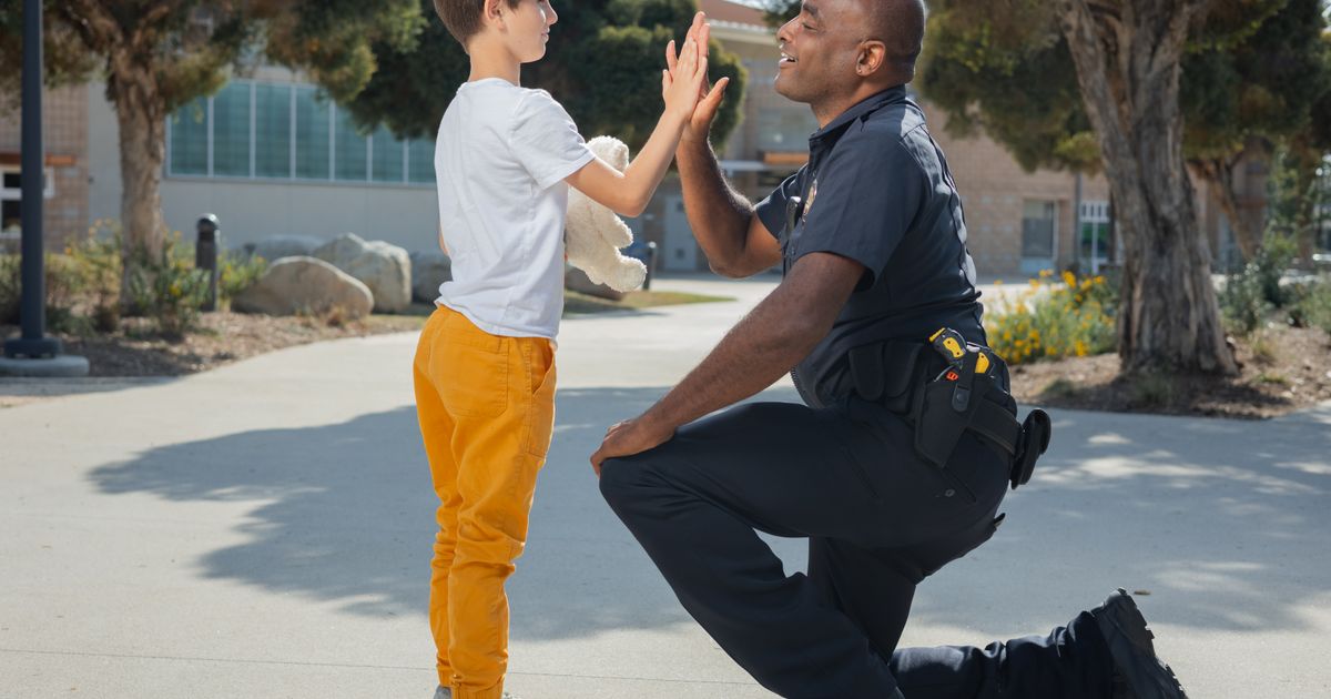Police officer greeting a young resident on the street, illustrating Dallas police recruitment video