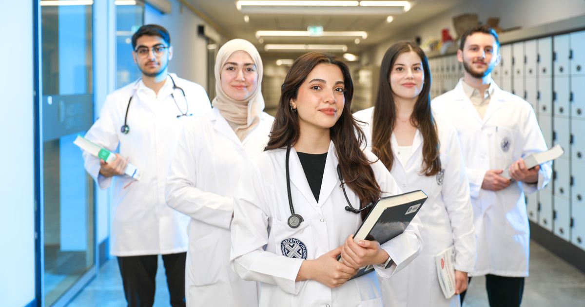 Medical students in white coats in a teaching hospital corridor, the kind of scene an NYC residency recruitment video is built around